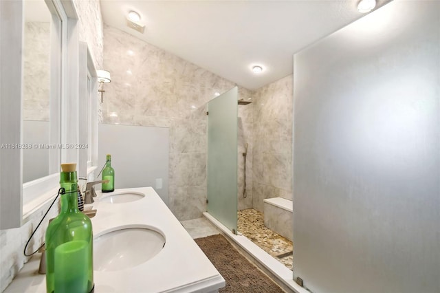 bathroom featuring a tile shower, tile walls, and vanity