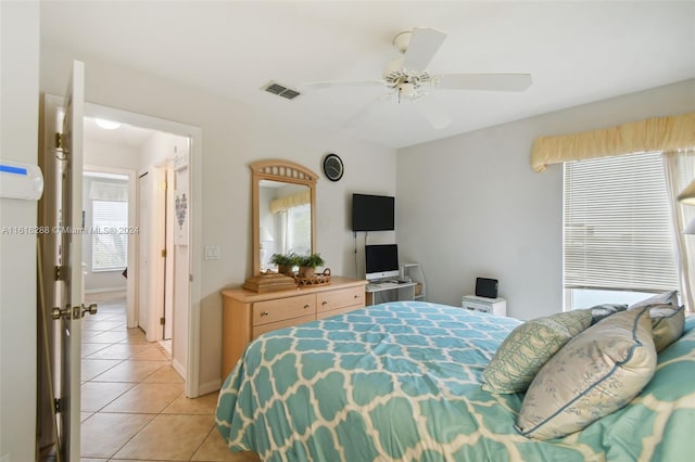 tiled bedroom featuring ceiling fan