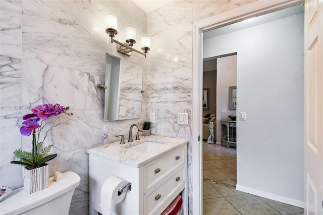 bathroom with tile walls, tile patterned floors, vanity, and toilet