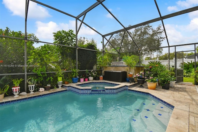 view of pool featuring glass enclosure and an in ground hot tub