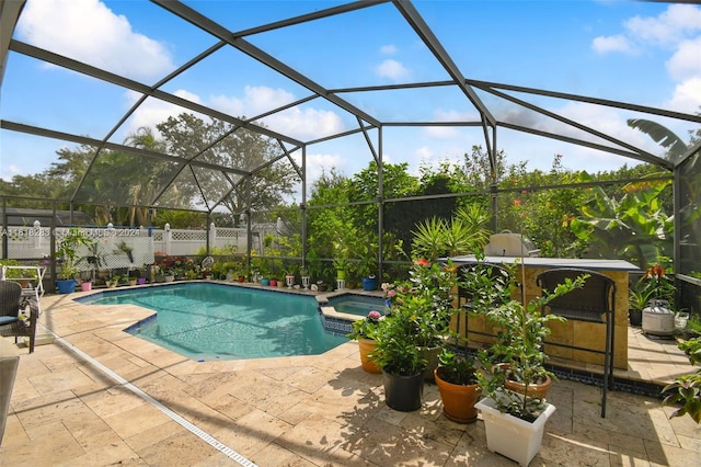 view of swimming pool featuring a patio, an in ground hot tub, and a lanai