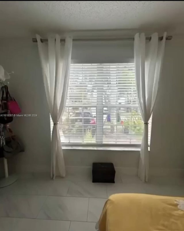 tiled bedroom with a textured ceiling