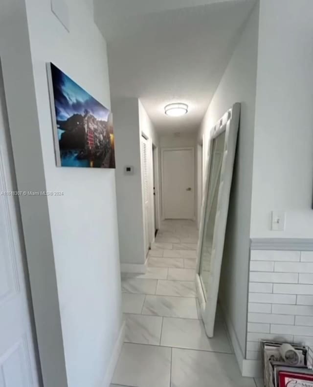 hall with light tile patterned floors