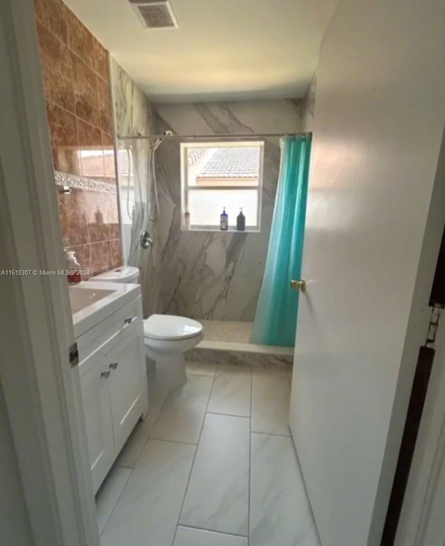 bathroom with tile patterned floors, toilet, vanity, and a shower with shower curtain