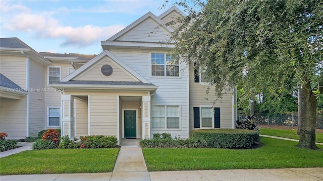 townhome / multi-family property featuring a front lawn