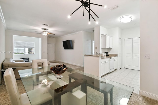 carpeted dining area featuring ceiling fan, sink, and crown molding