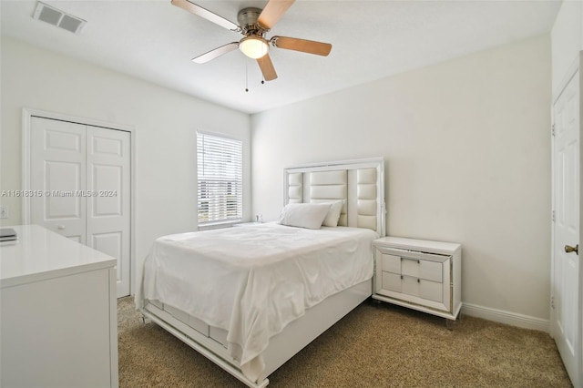 bedroom with a closet, dark colored carpet, and ceiling fan