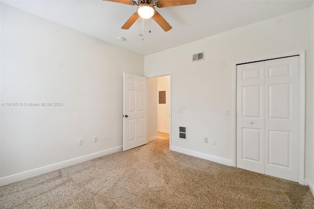 unfurnished bedroom with electric panel, light carpet, ceiling fan, and a closet