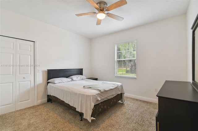 bedroom featuring ceiling fan, light colored carpet, and a closet