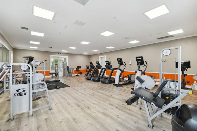 exercise room with light hardwood / wood-style floors