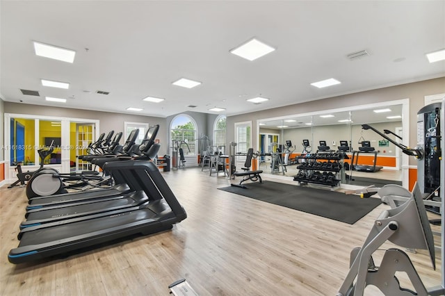 exercise room with light hardwood / wood-style floors and french doors