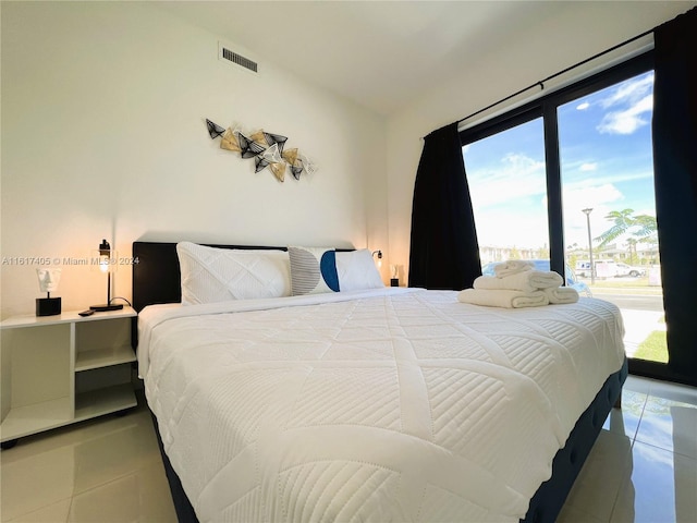 tiled bedroom featuring floor to ceiling windows