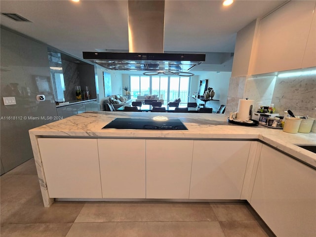 kitchen featuring island exhaust hood, white cabinetry, kitchen peninsula, and stainless steel gas stovetop