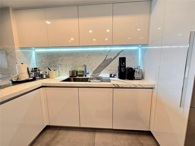 kitchen with tile patterned floors, sink, and backsplash