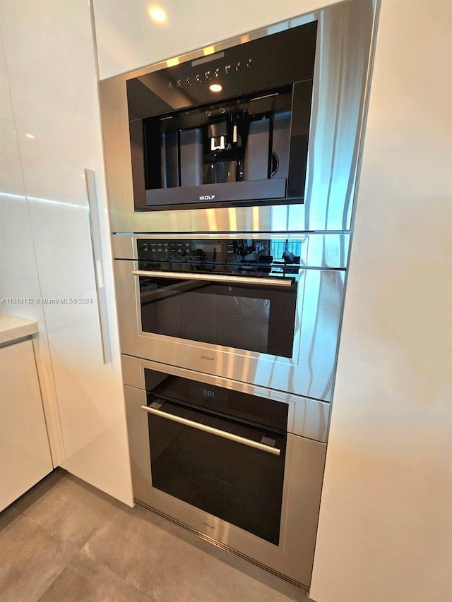 kitchen featuring light tile patterned floors and white cabinets