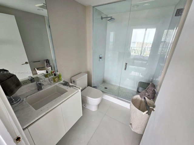 bathroom featuring tile patterned flooring, a shower with door, toilet, and vanity