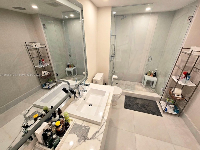 bathroom with tile patterned floors, vanity, toilet, and a shower with door