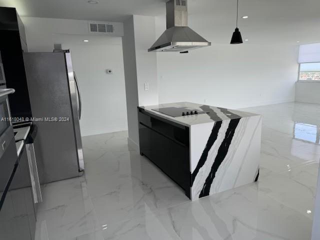 kitchen with stainless steel refrigerator, light tile patterned floors, wall chimney range hood, black electric stovetop, and hanging light fixtures