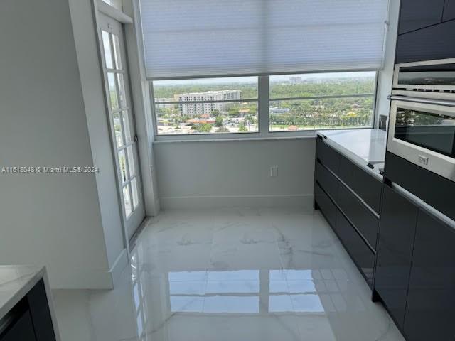 interior space featuring stainless steel oven and light tile patterned floors