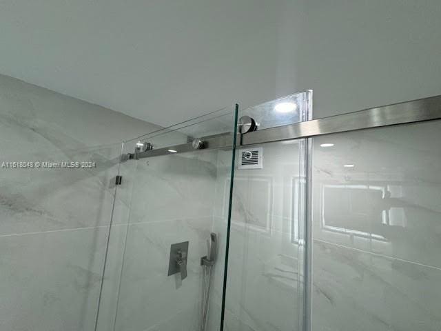 bathroom featuring a shower with door