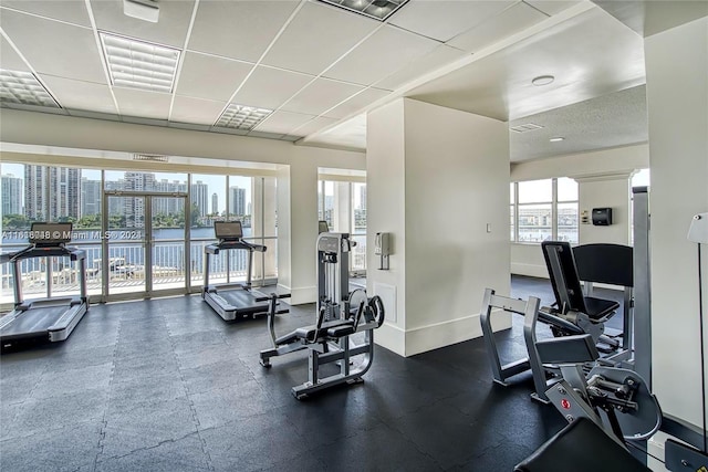 workout area with a paneled ceiling and plenty of natural light