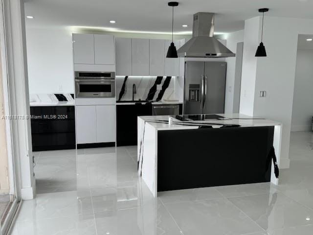 kitchen featuring pendant lighting, island exhaust hood, appliances with stainless steel finishes, light tile patterned floors, and backsplash