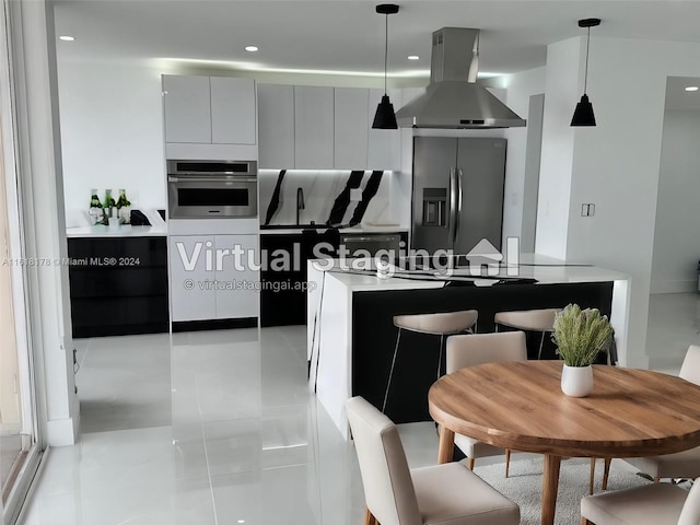 kitchen featuring light tile patterned flooring, gray cabinets, stainless steel appliances, island exhaust hood, and decorative light fixtures