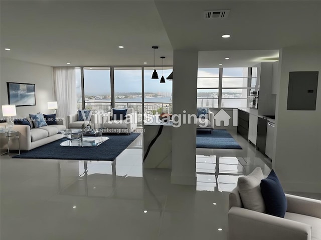 living room with expansive windows, a water view, tile patterned flooring, and electric panel