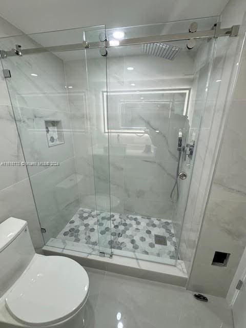 bathroom with walk in shower, tile walls, and toilet