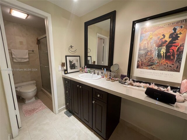 bathroom featuring vanity, tile patterned floors, a shower with door, and toilet