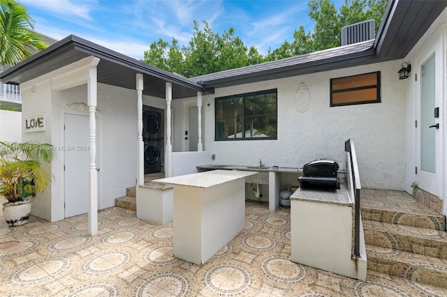 view of patio featuring cooling unit and stacked washer and clothes dryer