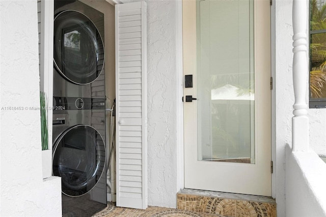 clothes washing area featuring stacked washer and dryer