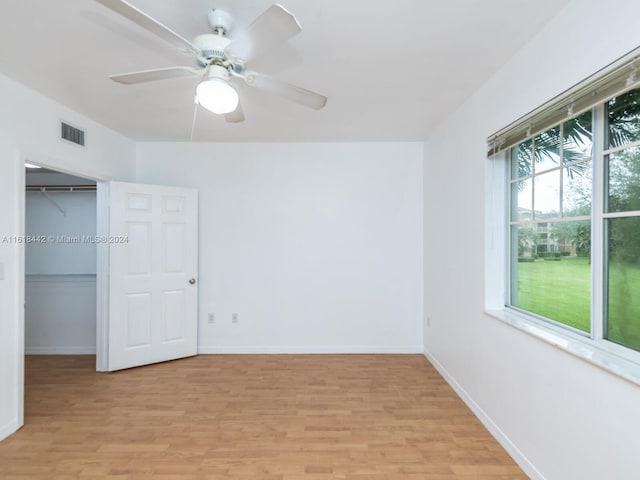 unfurnished bedroom with light hardwood / wood-style flooring, ceiling fan, and a closet