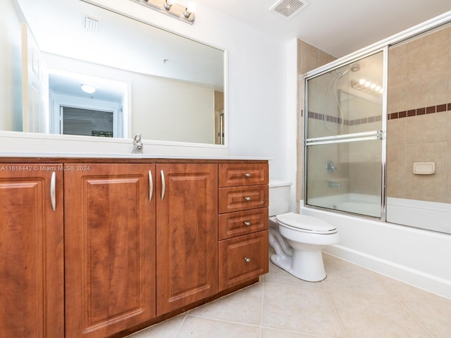 full bathroom featuring tile patterned floors, toilet, bath / shower combo with glass door, and vanity