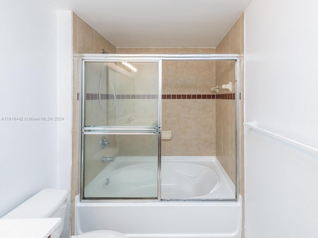 full bathroom with enclosed tub / shower combo, toilet, and vanity