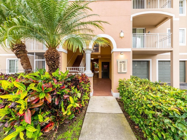 entrance to property featuring a balcony and a garage