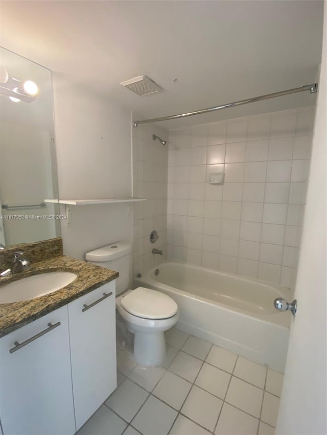 full bathroom featuring vanity, tiled shower / bath, tile patterned flooring, and toilet