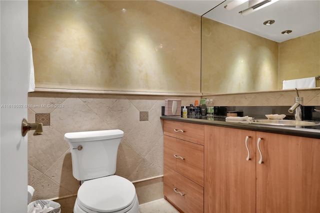 bathroom featuring vanity, backsplash, toilet, and tile walls