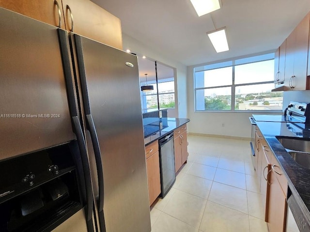 kitchen featuring light tile patterned flooring, stainless steel appliances, and dark stone countertops