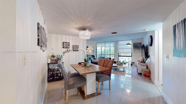 tiled dining room featuring a notable chandelier