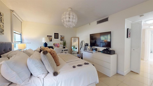 bedroom with light tile patterned floors and a notable chandelier