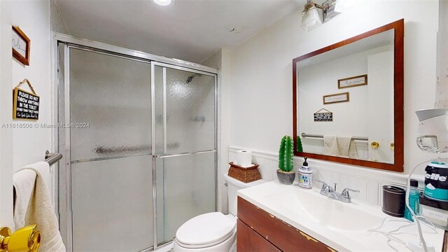 bathroom with vanity, toilet, and an enclosed shower