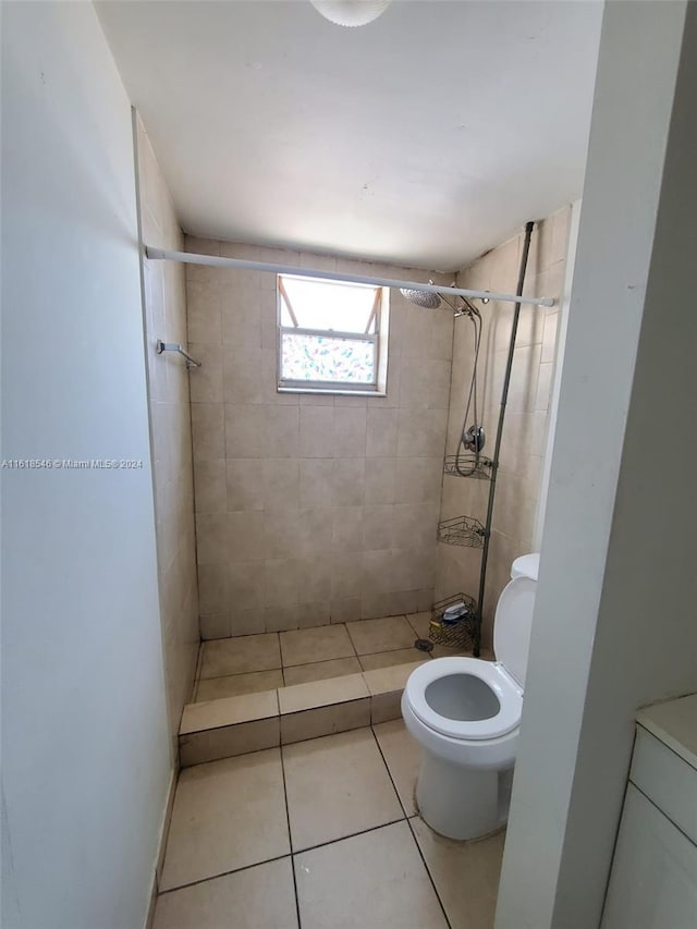 bathroom with tiled shower, toilet, and tile patterned floors