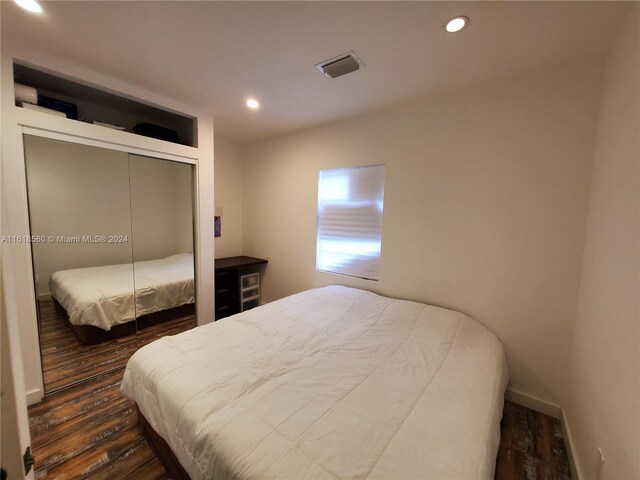 bedroom with a closet and dark wood-type flooring