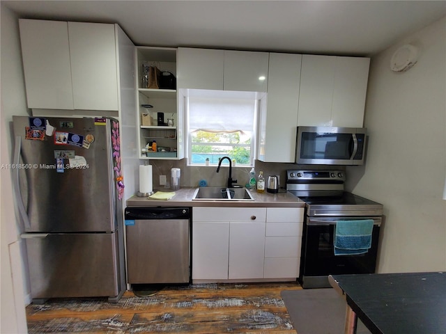 kitchen with decorative backsplash, sink, white cabinetry, and stainless steel appliances