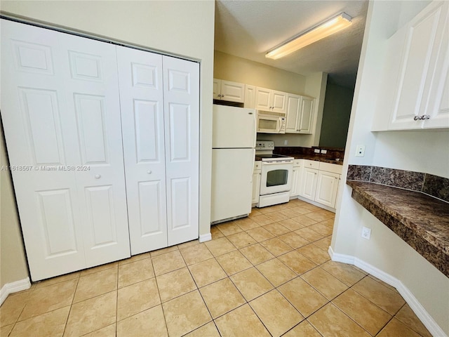 kitchen featuring white cabinets, white appliances, and light tile patterned flooring