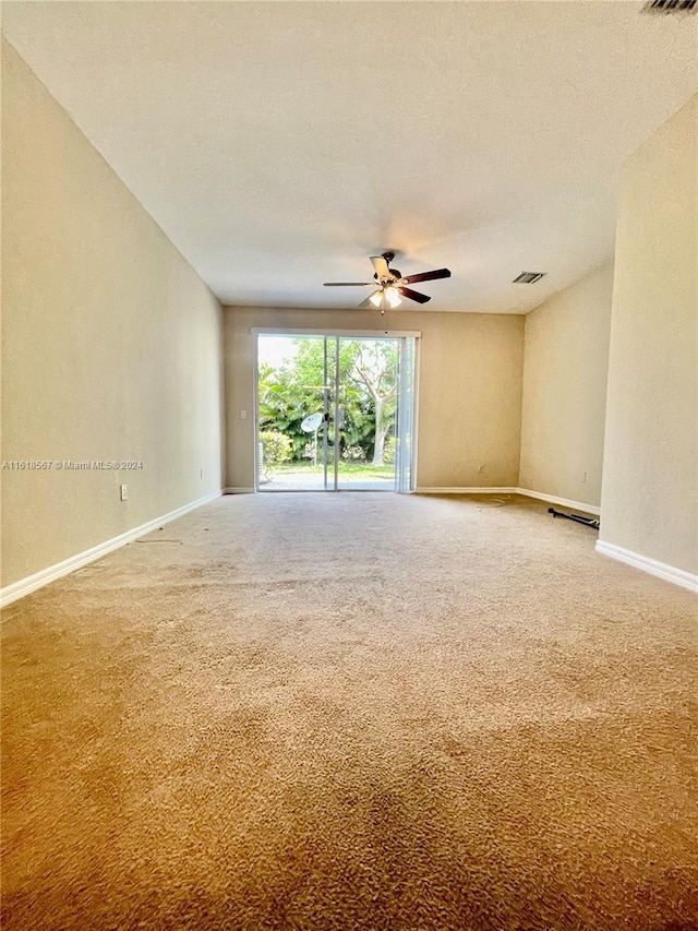 carpeted spare room with ceiling fan and a textured ceiling