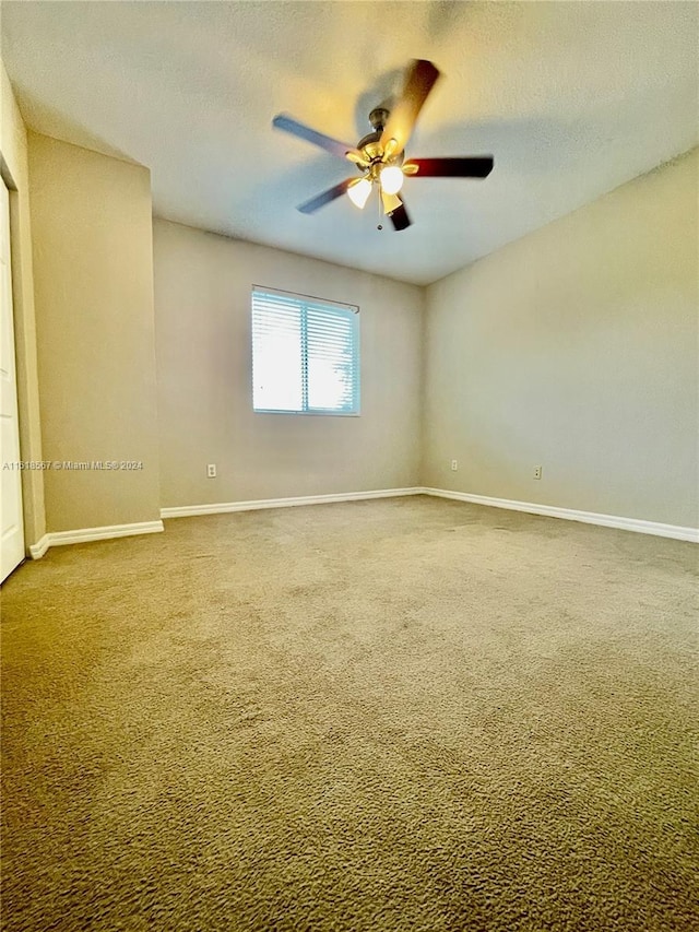 carpeted spare room featuring ceiling fan