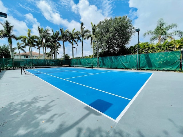 view of tennis court with basketball hoop