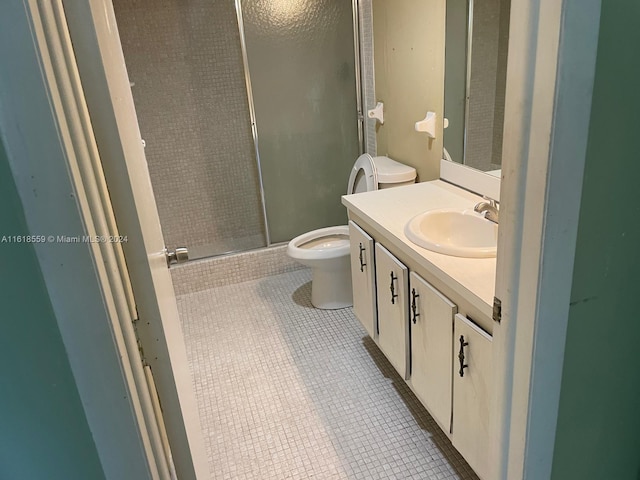 bathroom featuring toilet, tile patterned flooring, walk in shower, and vanity